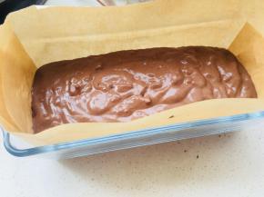 模具中放置油纸。将混合好的巧克力糊倒入模具，轻震。