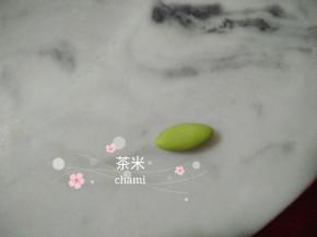 绿色的面团搓椭圆形后，擀成薄片。