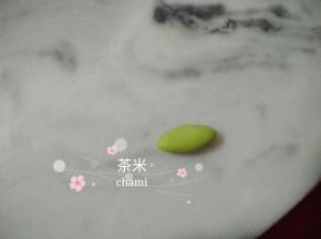 绿色的面团搓椭圆形后，擀成薄片。