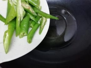 另起一个炒锅加入适量的油烧热后，把青椒放入锅中翻炒几下