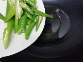 另起一个炒锅加入适量的油烧热后，把青椒放入锅中翻炒几下