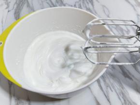 电动打蛋器高速打发，打至湿性发泡时加入最后的三分之一糖，，继续打发至蛋白出现细腻的纹路，将电动打蛋器调低速打发一会儿，感觉有些阻力时，就可以停止打发，以免消泡，提起打蛋器有微微的弯勾就可以，如图