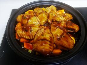 把鸡翅铺在南瓜胡萝卜上，倒入腌制的酱汁，