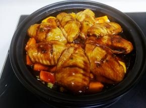 把鸡翅铺在南瓜胡萝卜上，倒入腌制的酱汁，