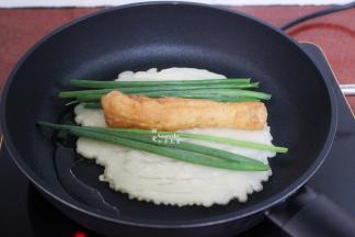 煎至微黄，放入油条、香葱；