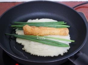 煎至微黄，放入油条、香葱；