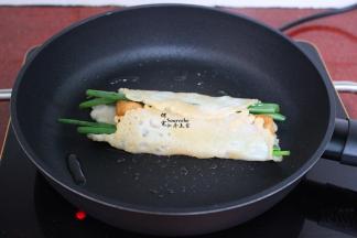 把油条、香葱卷起来，并且用锅铲压紧实；