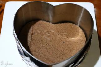 用学厨慕斯模具按压出两个心型，另一个稍微比之前的小一点，可以自己修一修。大的垫在慕斯圈底部，慕斯圈要用锡纸包住两层，以免慕斯液漏出。