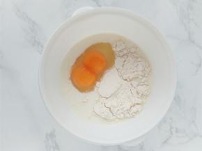 加热铸铁锅时，把鸡蛋，牛奶，面粉，盐，糖放入碗中，一起搅拌均匀。（图中是一个蛋，双黄而已）