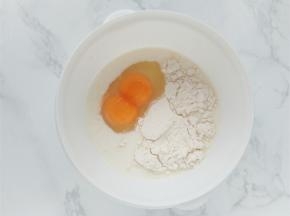 加热铸铁锅时，把鸡蛋，牛奶，面粉，盐，糖放入碗中，一起搅拌均匀。（图中是一个蛋，双黄而已）