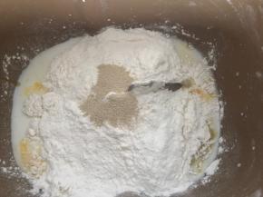 把面包料除黄油外的所有食材放入面包机桶内，启动搅拌键进行揉面，揉至光滑面团