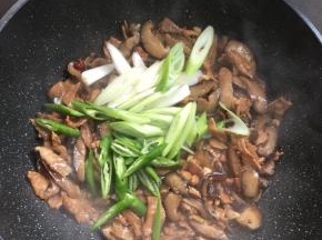 放入青尖椒和大葱翻炒均匀。