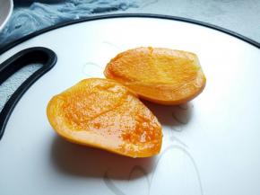 芒果果蒂切一刀，刀再贴着果核对半切开。