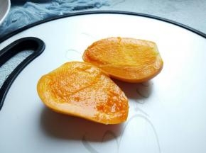 芒果果蒂切一刀，刀再贴着果核对半切开。