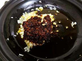 六分热时放入蒜泥和豆瓣酱爆香