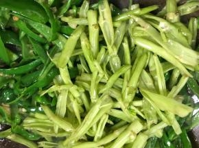 加入青椒和空心菜梗，大火翻炒均匀