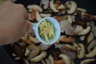 加入清水和姜丝，中火翻炒至香菇变软出水