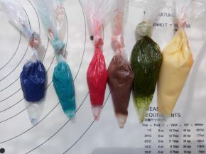 这个时候我们来做酥皮：把软化好的黄油与糖粉混合均匀，加入全蛋液搅拌均匀，再把奶粉与低筋面粉混合过筛后放入。全部混合均匀后，分份并分别加入需要的色素或者色粉进行调色。调好装入裱花袋备用。