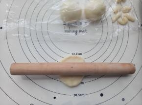取一份面团擀成6cm左右的小牛舌形，然后再用手团成圆形，耳朵部分可以是圆形也可以是长条形的。耳朵做好后盖保鲜膜备用。