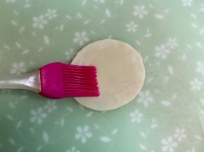 在饺子皮上刷一层油。