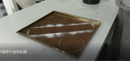 3.拿走纸条/油布，这时候我们就得到一个整齐的宽度印记。慕斯圈/活底模具沾低筋面粉再印出两个圆形，放置一旁备用