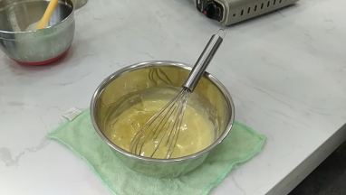 11.将【步骤10】倒入锅中进行加热，一边搅拌一边加热至82℃。如果没有温度计就加热至边缘开始出现小气泡沸腾时就离火。离火后加入泡软的吉利丁片搅拌融化至混合均匀