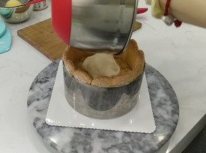 17.先铺上切成小块的白桃块，然后倒入剩余的巴巴露亚馅，用刮刀推平表面后放入冰箱冷藏