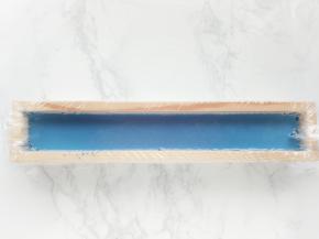 取一个长条形容器，铺上保鲜膜，将奶液过筛倒入容器中，送入冰箱冷藏4小时以上。