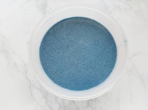 碗中打入鸡蛋，打散后加入蝶豆花牛奶拌匀，分几次把蛋奶液倒入面粉中，边倒边拌匀。再加入融化的黄油，拌匀。将拌好的面糊过筛一次，可丽饼面糊完成。