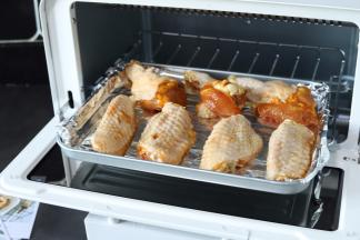 将装有鸡翅的烤盘放入烤箱