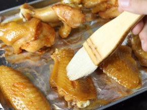 15分钟后取出鸡翅，刷上蜂蜜水，翻面，再均匀的刷上蜂蜜水