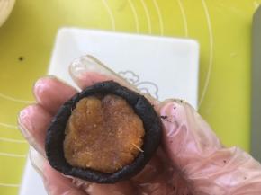 取17克凤梨馅，放到面皮中间，用虎口一点点推揉面团，包裹上凤梨馅