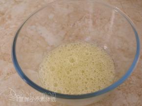 电动打蛋器低速将蛋白搅打至起鱼眼泡，加入1/3的糖粉。