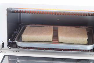 将装有吐司片的烤盘放入烤箱内