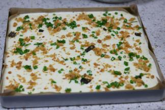 蛋黄和蛋白混合翻拌均匀，倒入铺了油布的金盘里，撒上适量肉松和葱花