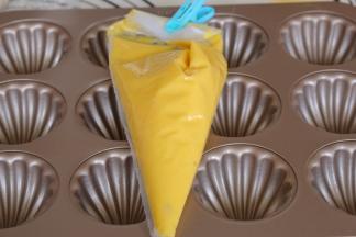 冷藏好的蛋糕糊取出恢复室温，模具涂抹黄油防止粘，椰蓉馅料等分12分揉圆