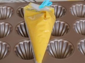 冷藏好的蛋糕糊取出恢复室温，模具涂抹黄油防止粘，椰蓉馅料等分12分揉圆