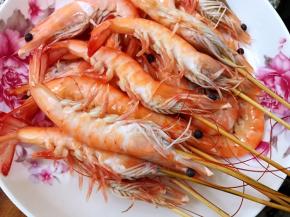 虾刷洗干净后穿上竹签后煮熟