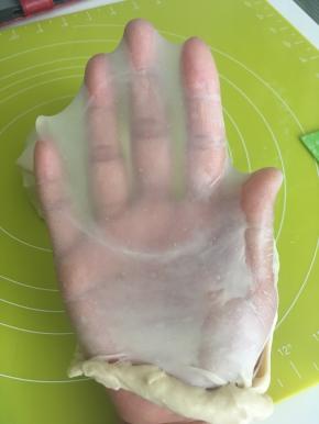 揉好的面团，切下一小块，双手慢慢撑开，可以撑出薄薄地有弹性的手套膜