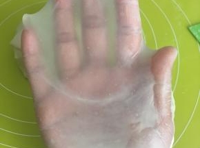 揉好的面团，切下一小块，双手慢慢撑开，可以撑出薄薄地有弹性的手套膜