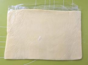 裹入用黄油，装入保鲜袋，对折保鲜袋，用擀面杖擀成薄片，入冰箱冻硬