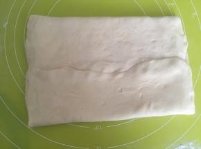 将两侧面片对折，包裹上黄油，捏紧收口