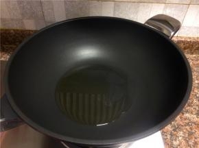 热锅倒油烧至八成热。