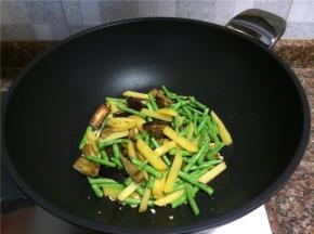 放入茄条、豇豆和土豆翻炒1分钟。
