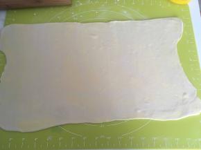取出冷冻的面团，撒点干粉，擀成长方形，厚度约为0.2厘米左右