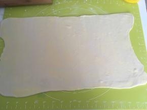 取出冷冻的面团，撒点干粉，擀成长方形，厚度约为0.2厘米左右
