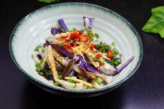 爆香的香料连同油一起倒入装好手撕茄子的大盘子里，晒上葱，拌均，就美味新鲜，可以享用了。