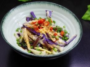 爆香的香料连同油一起倒入装好手撕茄子的大盘子里，晒上葱，拌均，就美味新鲜，可以享用了。