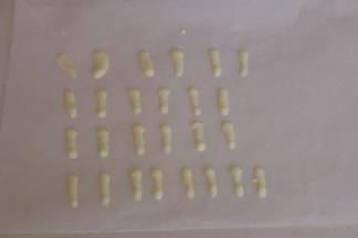 取一张烘焙油纸，将白色巧克力挤出耳朵