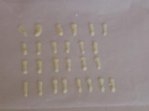 取一张烘焙油纸，将白色巧克力挤出耳朵